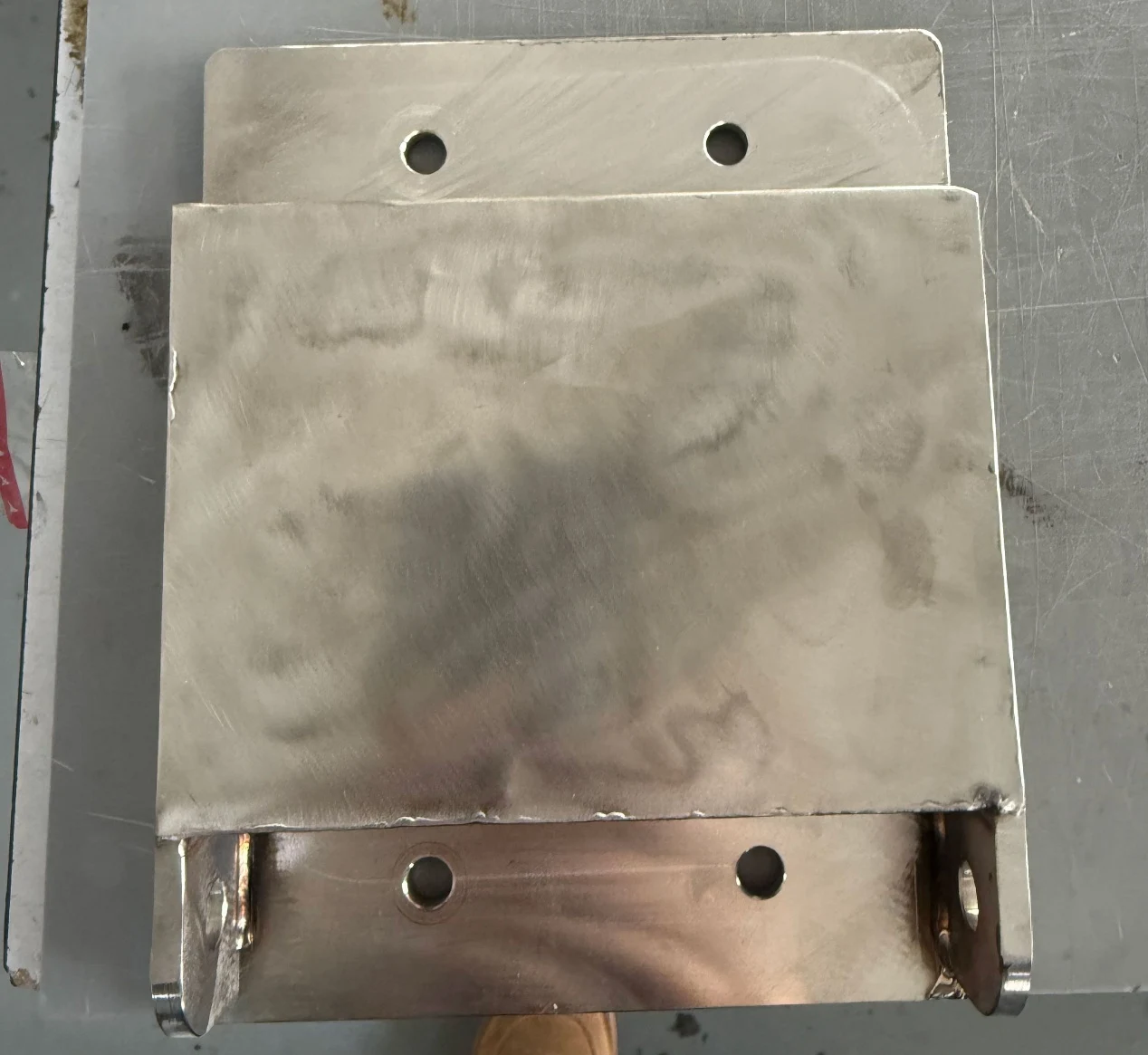 Fabricated metal housing with welded features and mounting holes
